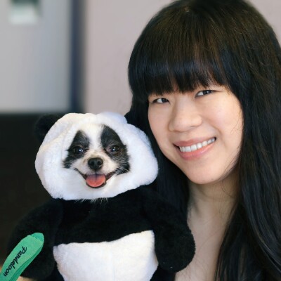 An image of Pandaloon CEO, Eugenia Chen, and her small black and white dog dressed in a panda costume