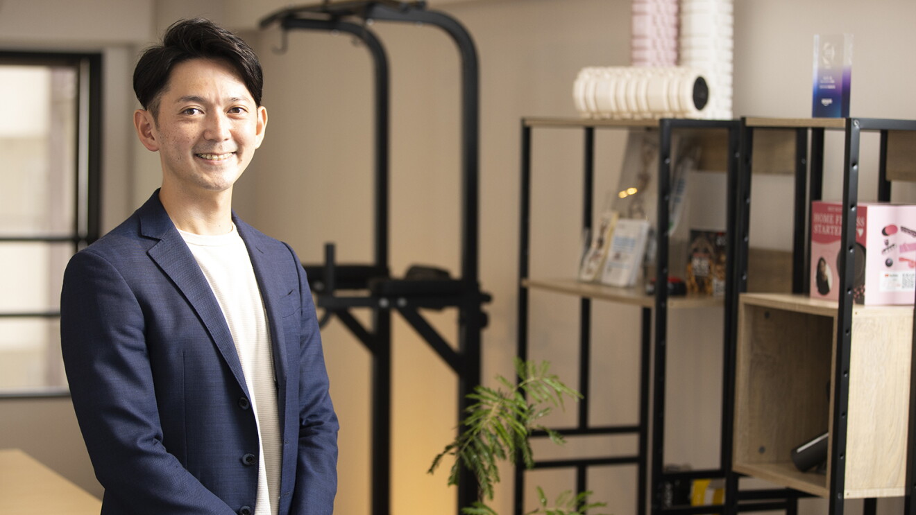 取扱うフィットネス器具と笑顔の山田さん