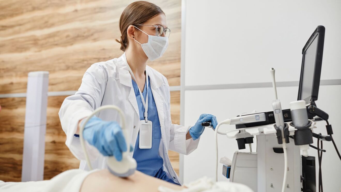 Medical professional operating ultrasound equipment in clinical setting