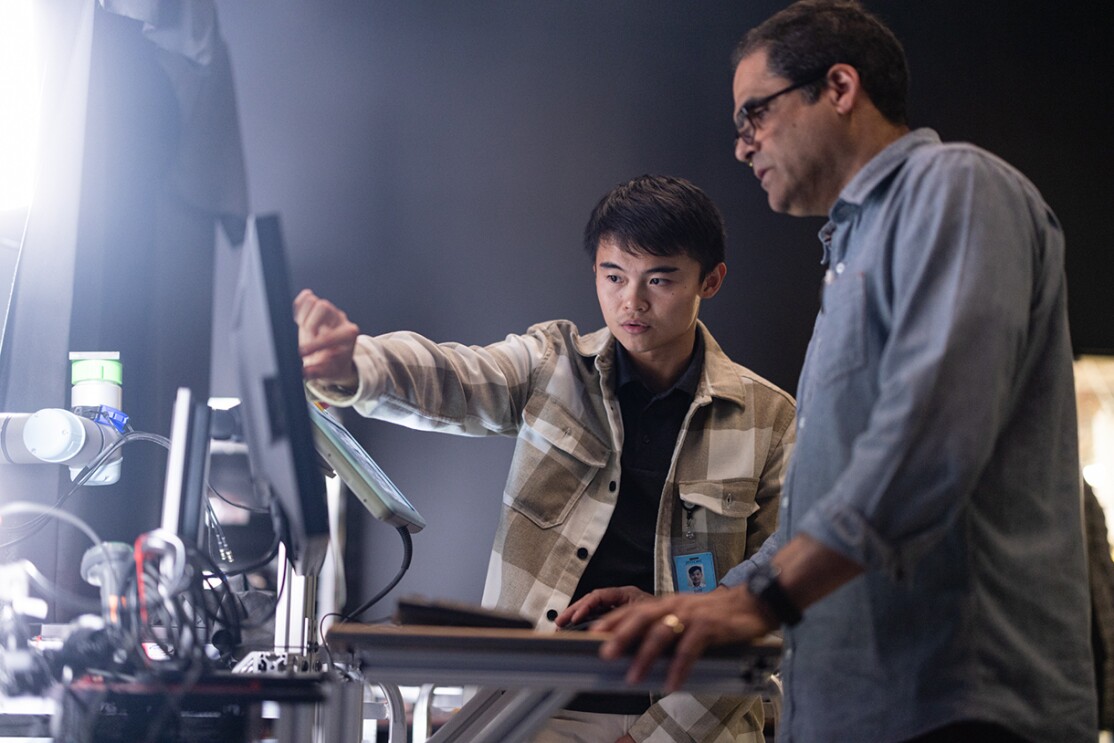 Prime Air employees at a R&D facility work together at computer screens.