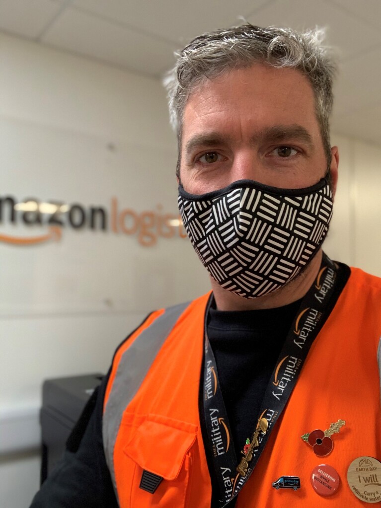 Amazon employee wearing  a mask and orange high vis vest 