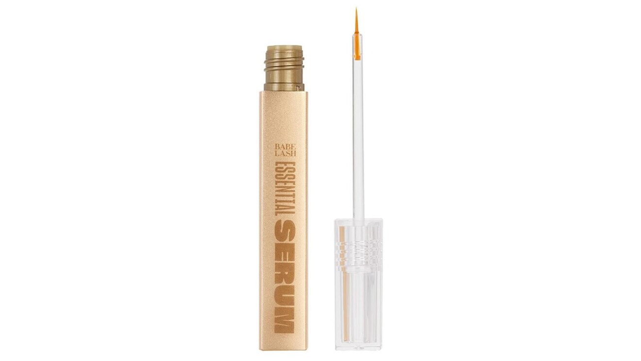 An image of the Babe Original lash serum. It's in a small, cylinder tube with a gold base and a white lid. There is a small applicator brush at the end of the lid.