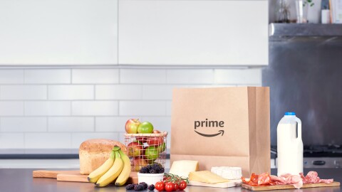 Paper bag with prime logo, milk carton and basket of fruit 