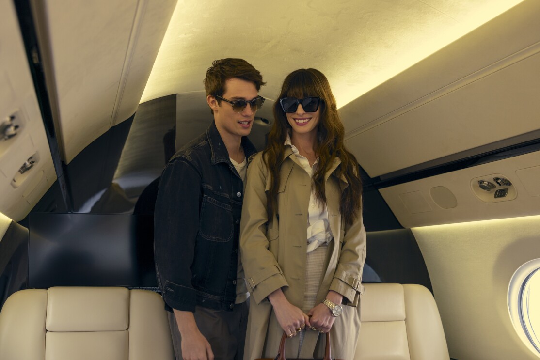 A man and a woman wearing sunglasses inside a private plane