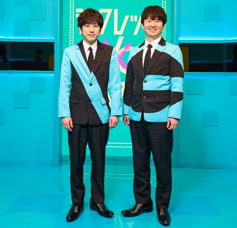 水色の部屋に立つ笑顔の男性2人(二宮和也 と若林正恭)が、水色と黒で色分けされたジャケットを着ている。ジャケットの黒い部分がNGと読める