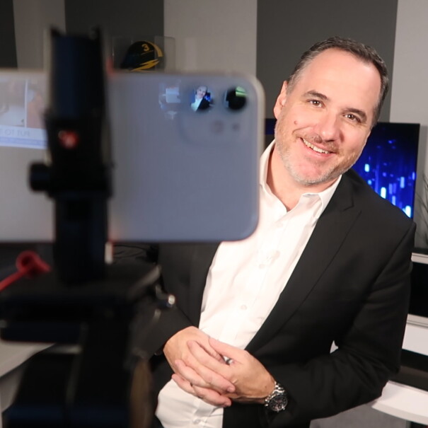 An image of Australian technology commentator Trevor Long being filmed on phone.