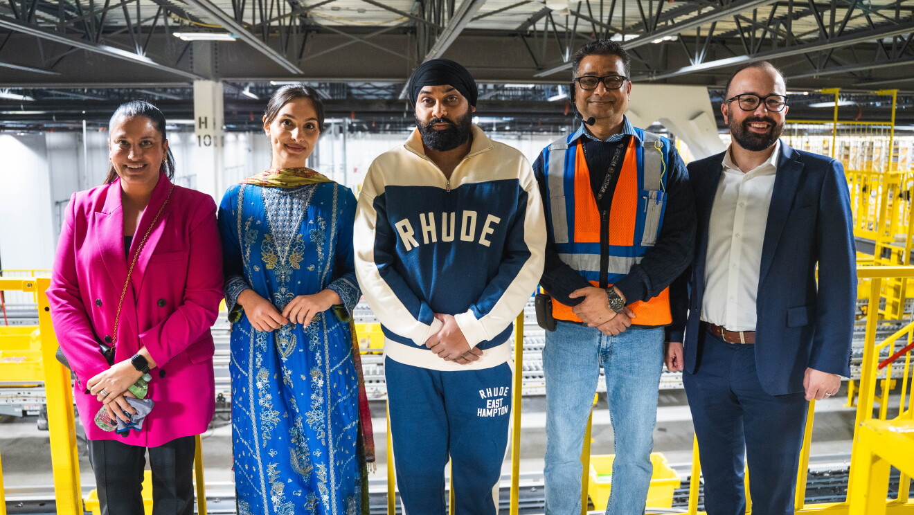 Nattan posing with a group of people in an Amazon warehouse