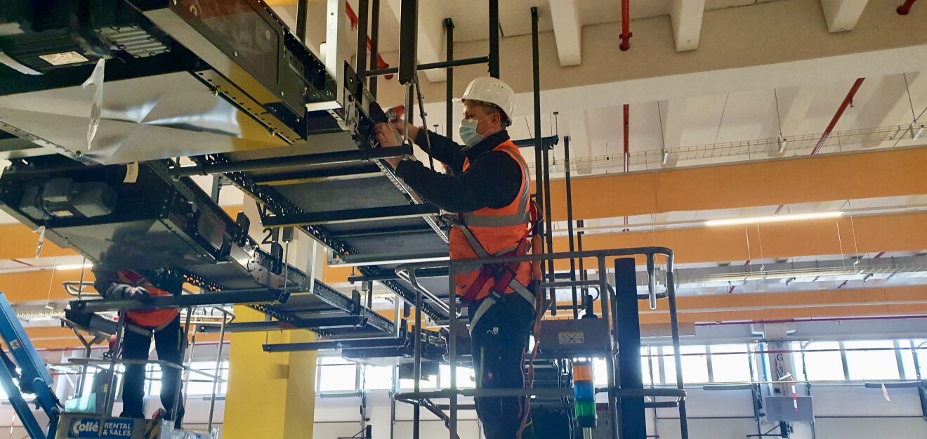 Techniker schraubt am Förderband