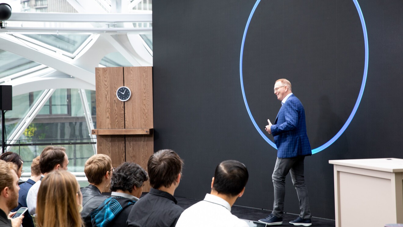 Amazon Devices VP David Limp on stage in front of a large image of the top of an Echo