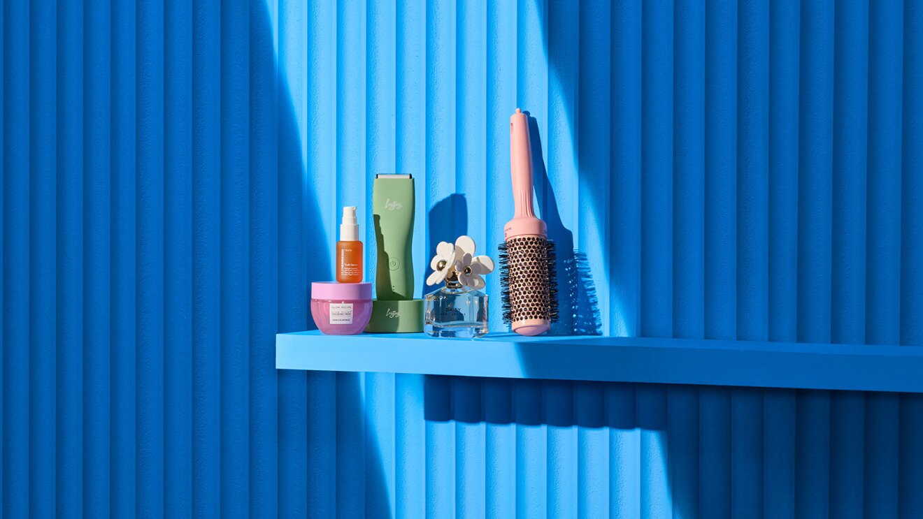 Beauty products arranged on blue shelf against vibrant blue backdrop