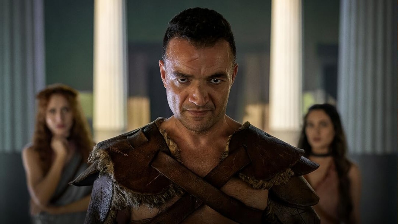 Nick E. Tarabay in Spartacus: House Of Ashurwith two women in the background. 