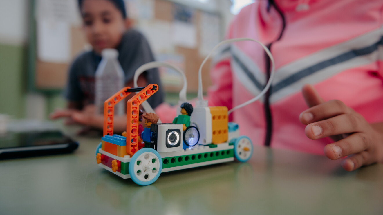 Robot creado con Legos Education Spike Essential. Tiene dos ojos con dos patas y unas palancas como si fuera un toro. 