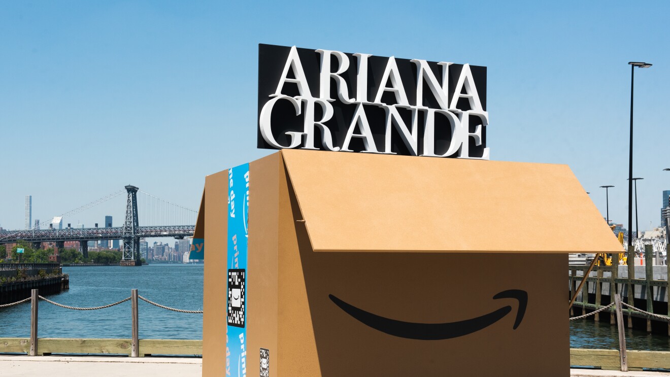 在海滨一个大型亚马逊的盒子。打开盒子,揭示音乐艺术家的名字,阿格兰德,在黑色背景白色的字母。