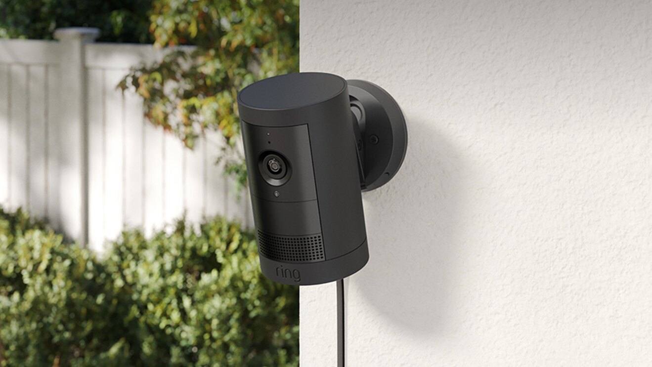 ブラックのセキュリティカメラ。屋外の壁に設置されている。