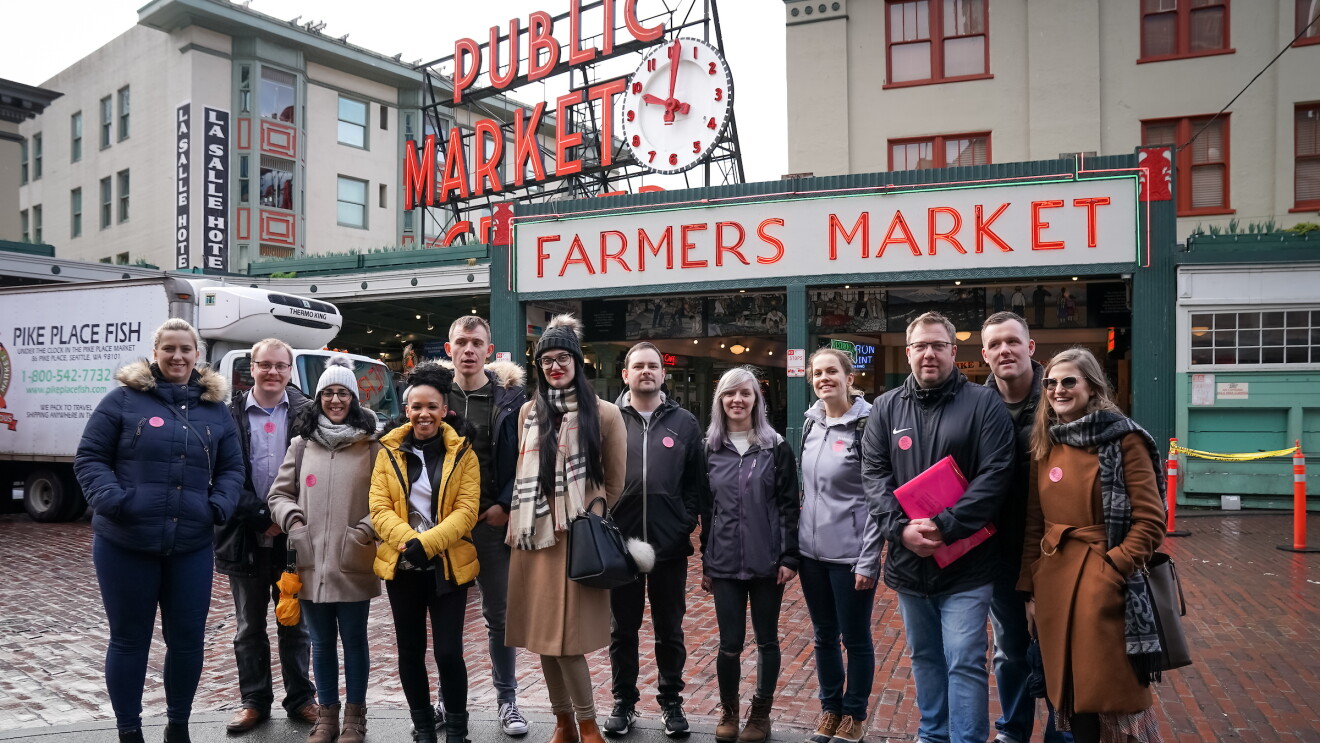 A group of Amazon employees from the 'I Found The Right Place' programme standing outside of a farmers market.