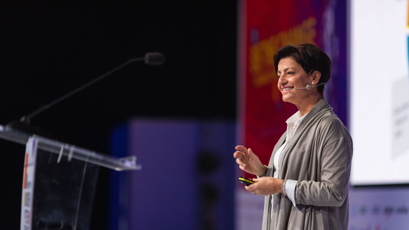 Giuseppina Smith z Amazon w UK uśmiecha się, przemawiając na scenie podczas konferencji Women in Tech Summit