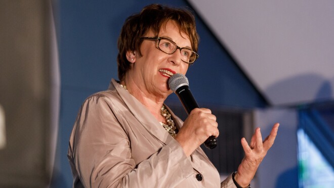 Brigitte Zypries steht auf der Bühne, sie hält ein Mikrofon in der Hand und schaut freundlich ins Publikum