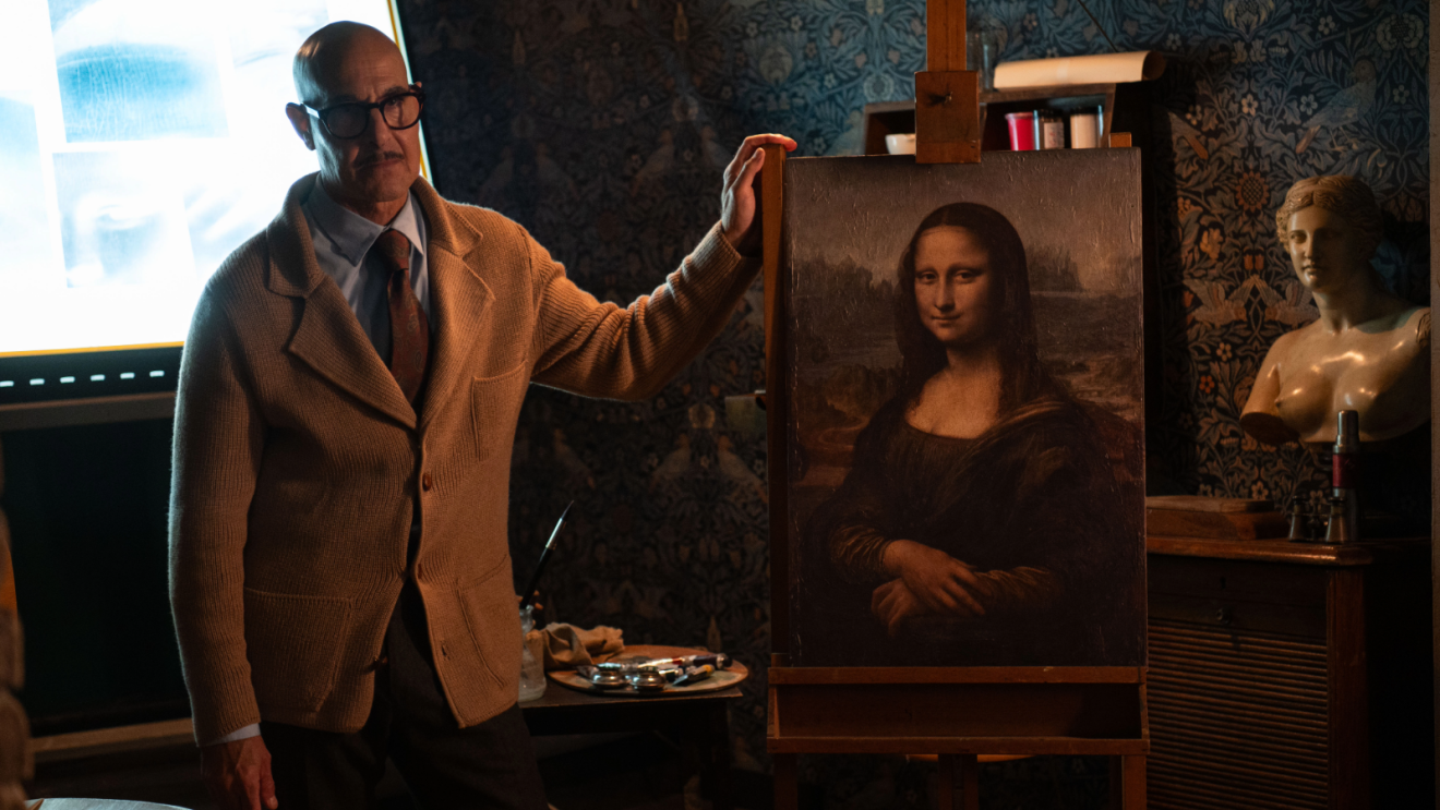 Stanley Tucci stands next to the Mona Lisa in Prime Video movie Masterplan