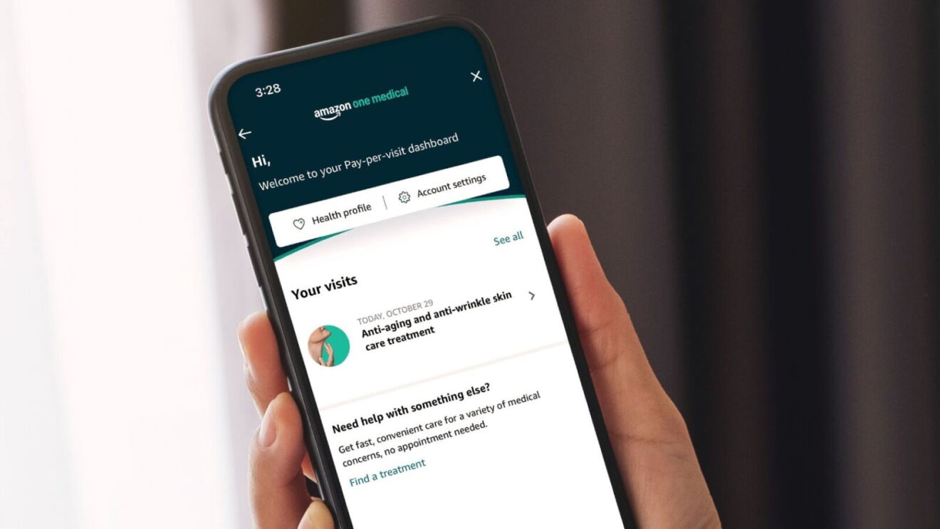 Hand holding smartphone displaying Amazon One Medical app dashboard