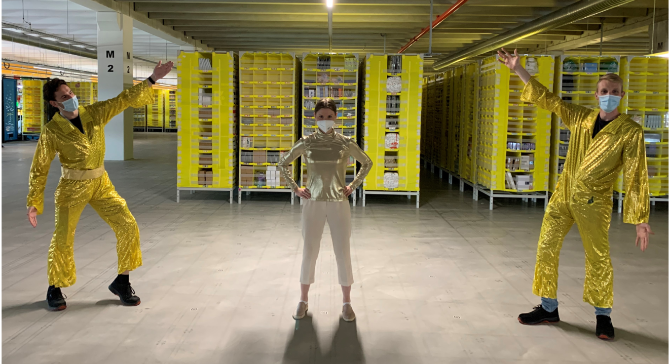 Drei Mitarbeiter:innen aus dem Logistikzentrum in Sülzetal in goldenen Anzügen.