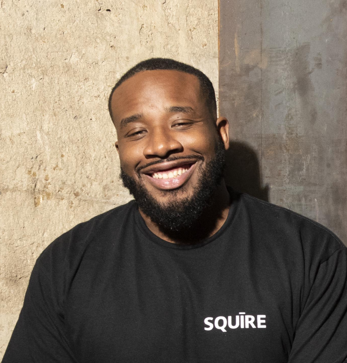 Dave smiling outside. He wears a black Squire T-Shirt.