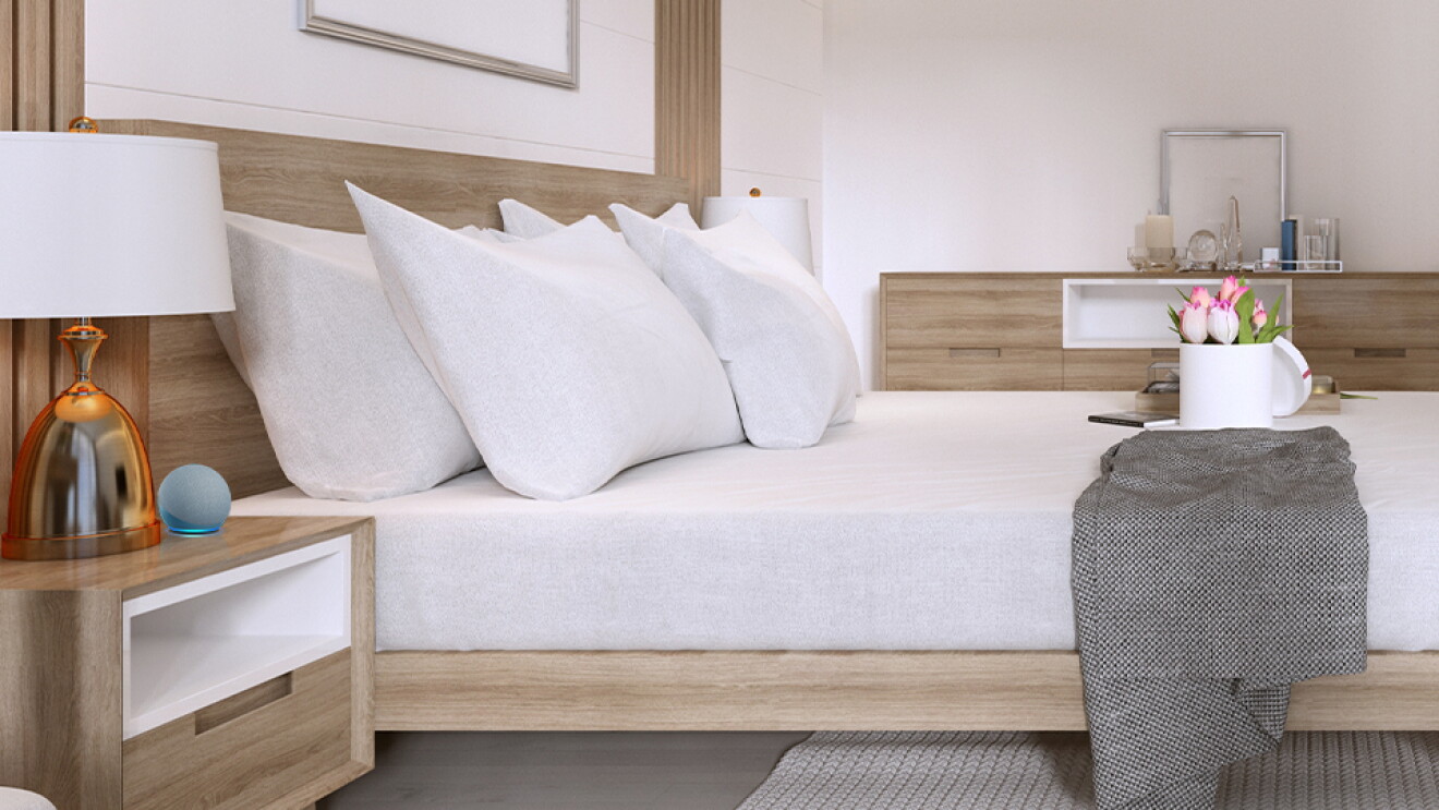 Photo of a hotel room with an Alexa Echo Dot device on the bedside table - Alexa Hospitality