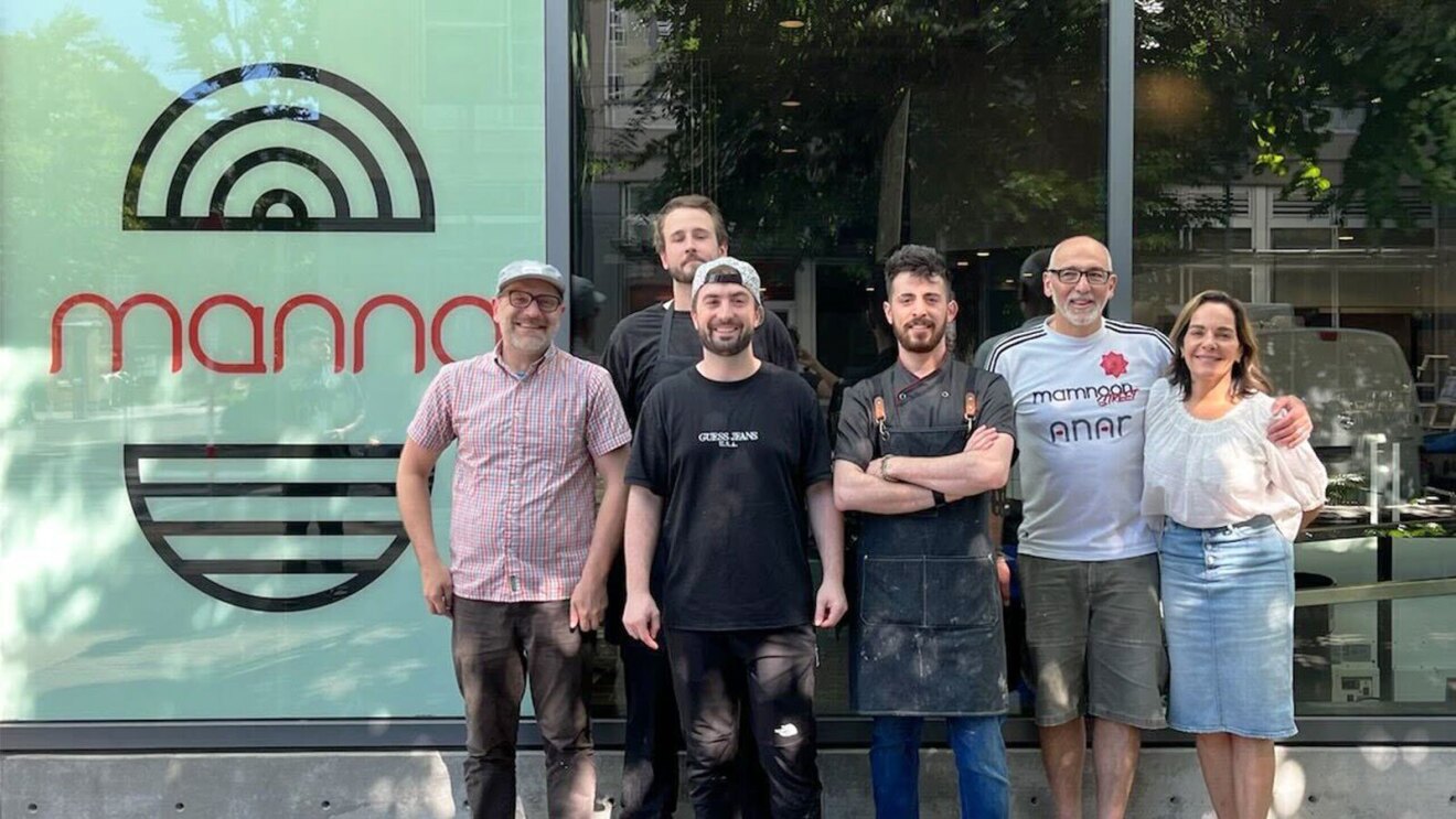 six people stand for a photo outside of the storefront for the "Mama" restaurant