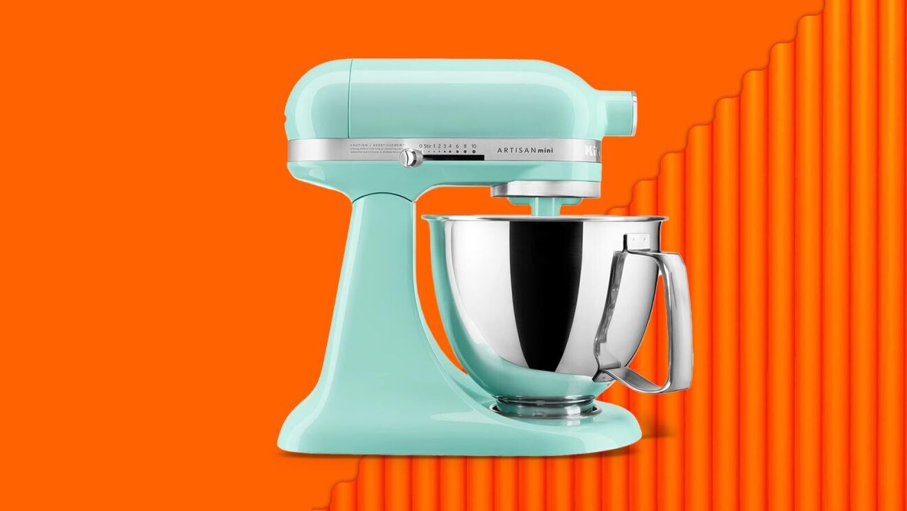 Mint green KitchenAid Artisan Mini stand mixer on vibrant orange background