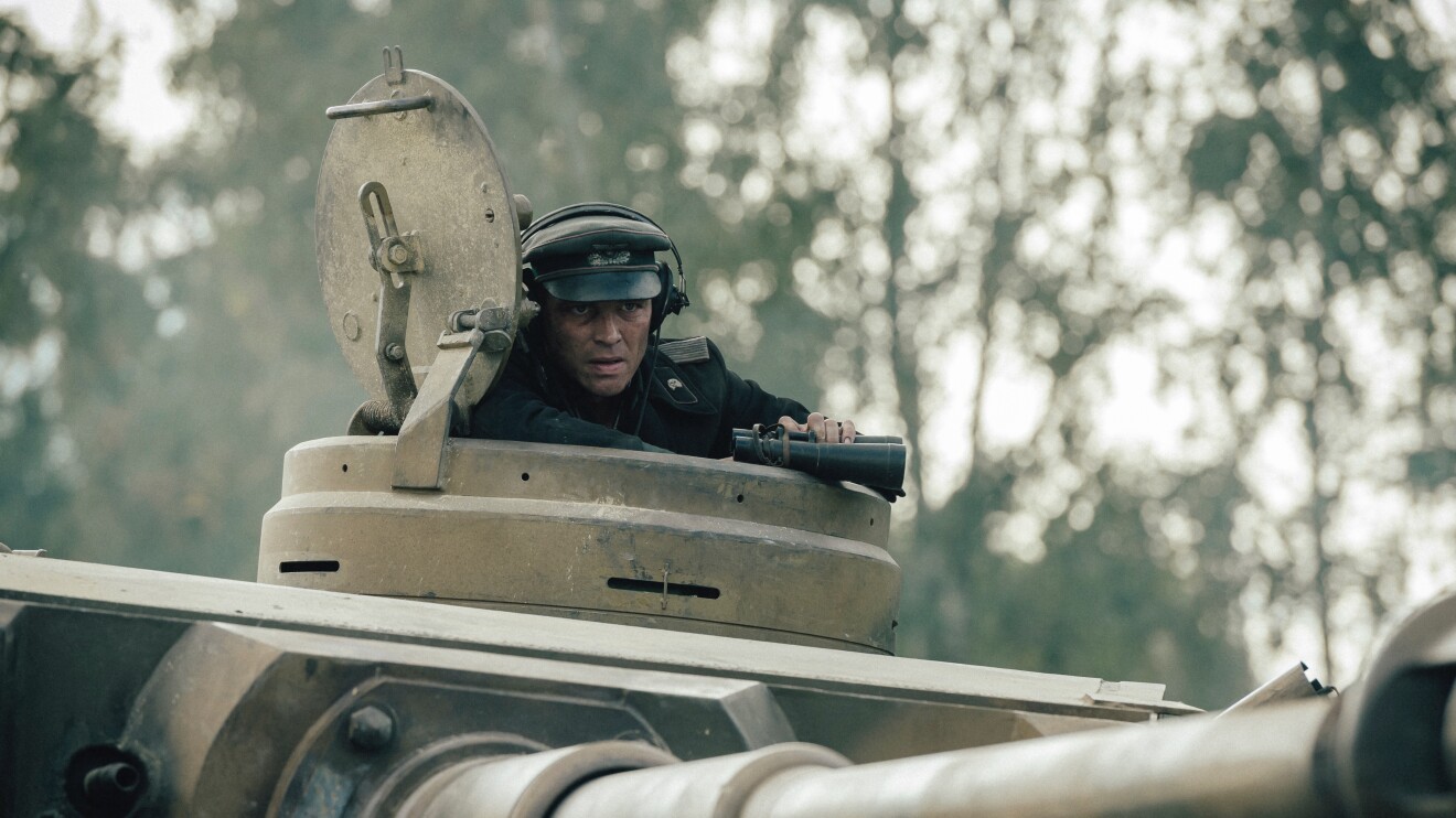 The Tiger bei Prime Video: Ein Soldat späht aus einem Panzer, er hält ein Fernglas in der Hand.
