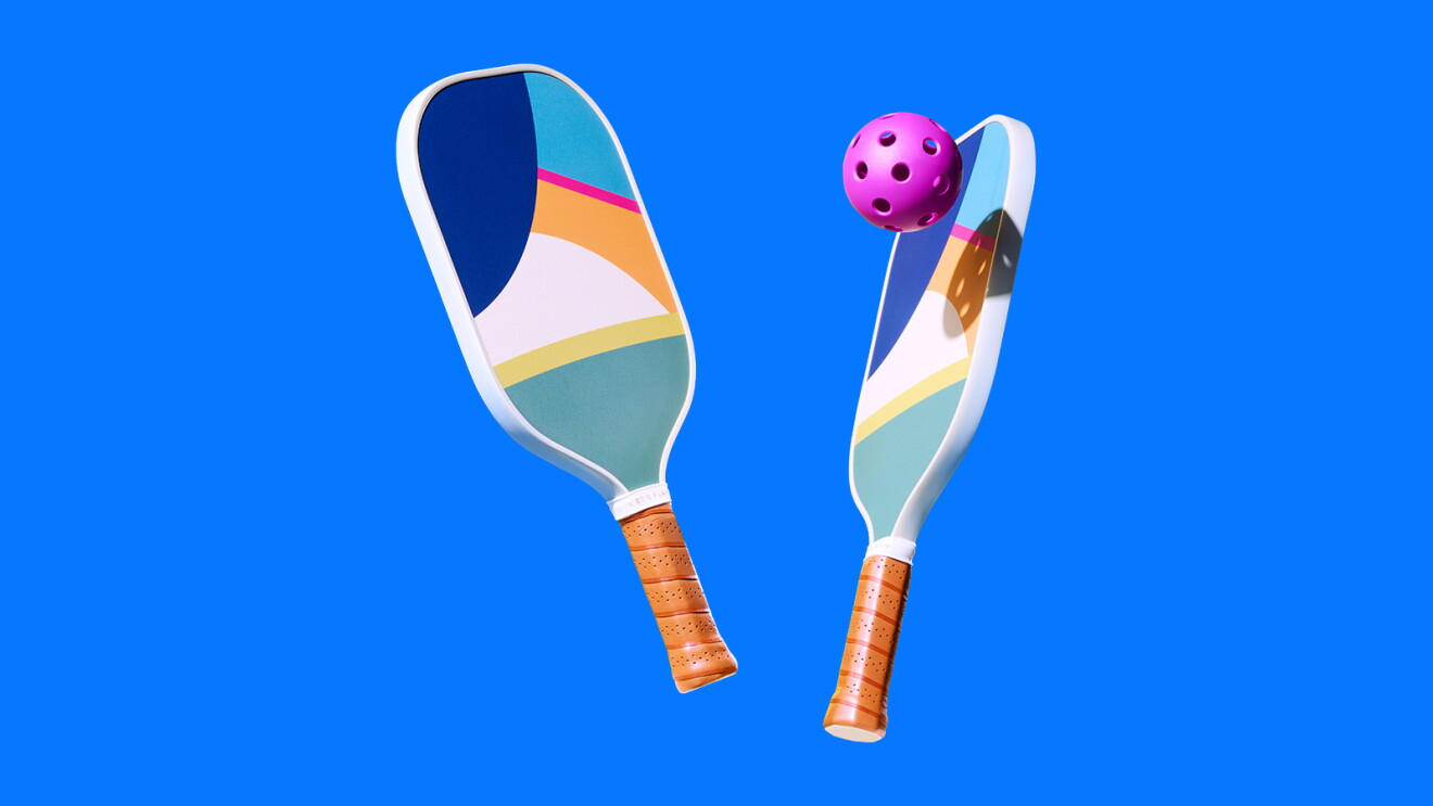 Raquettes et balle de pickleball colorées sur fond bleu vif