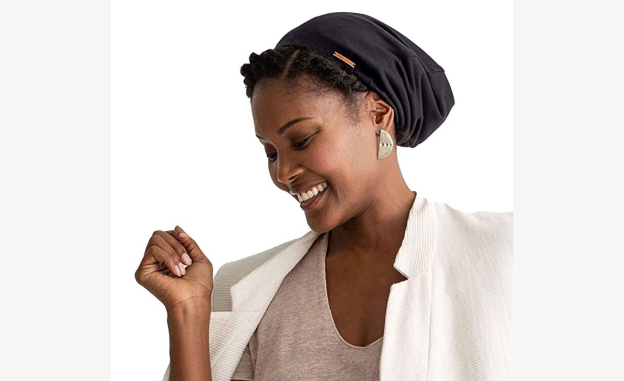 Woman wearing Grace Eleyae satin lined cap and smiling. 