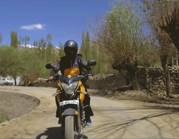 A motorcycle drives along winding roads.