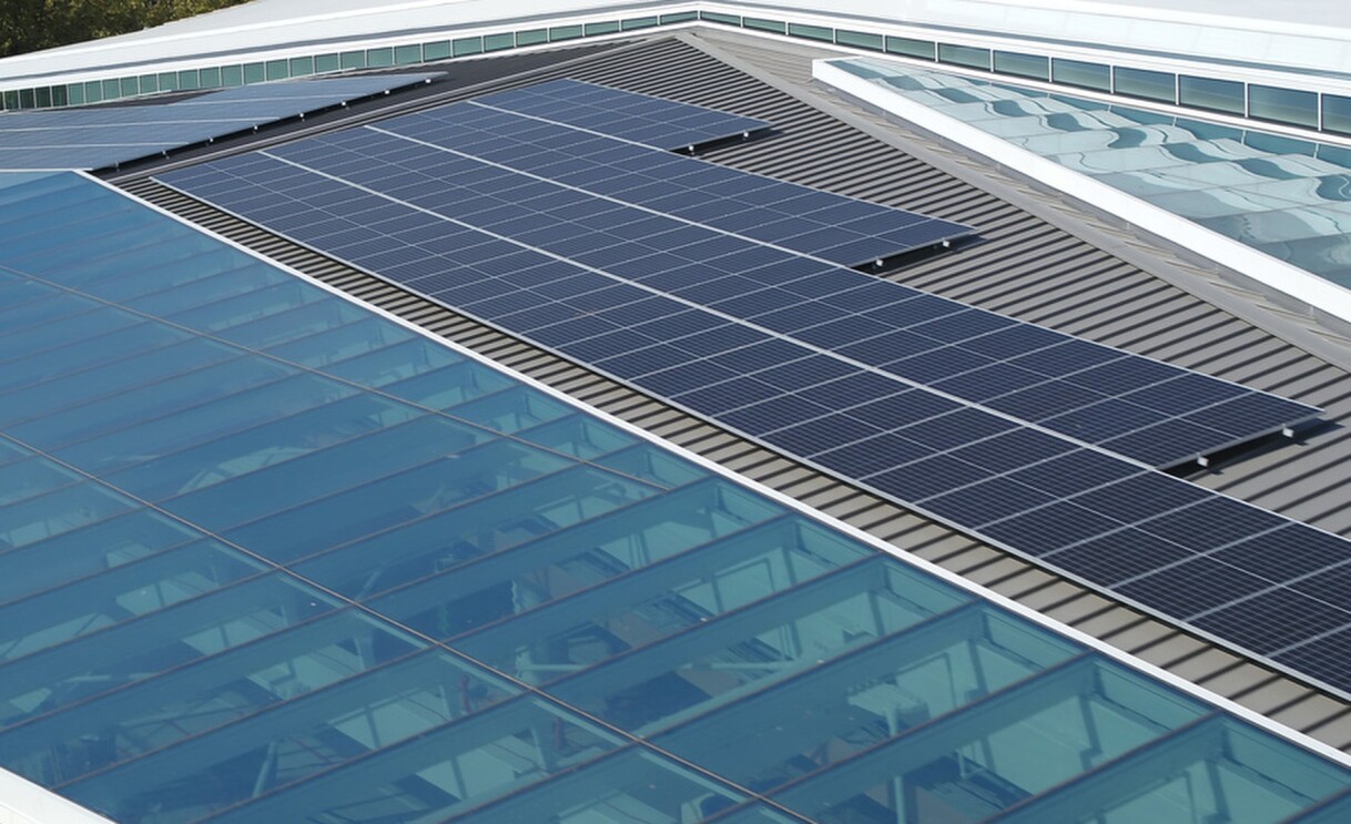 An image of solar panels atop a large roof on the Climate Pledge Arena.