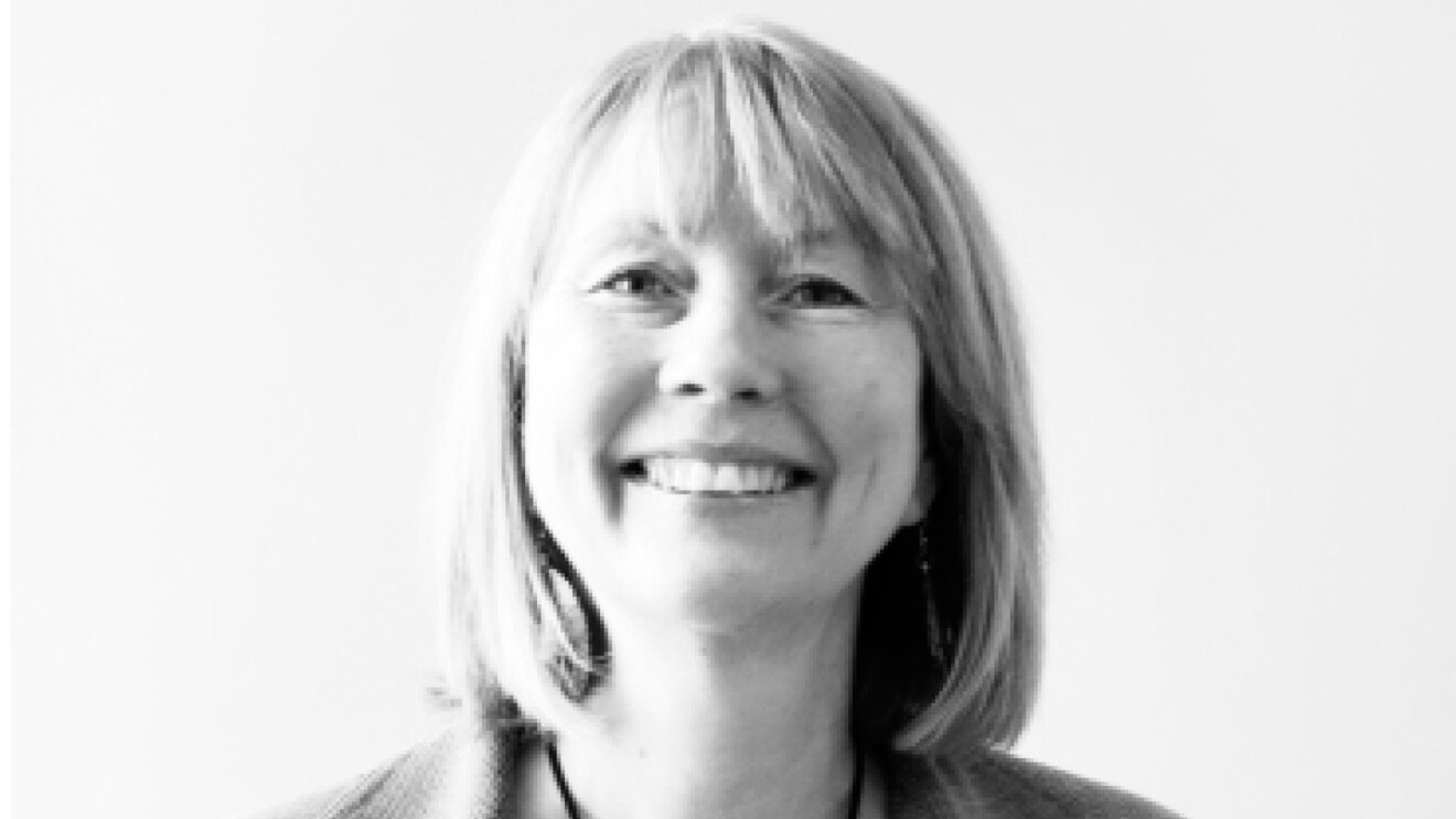 A black and white image of a woman smiling for a headshot photo.