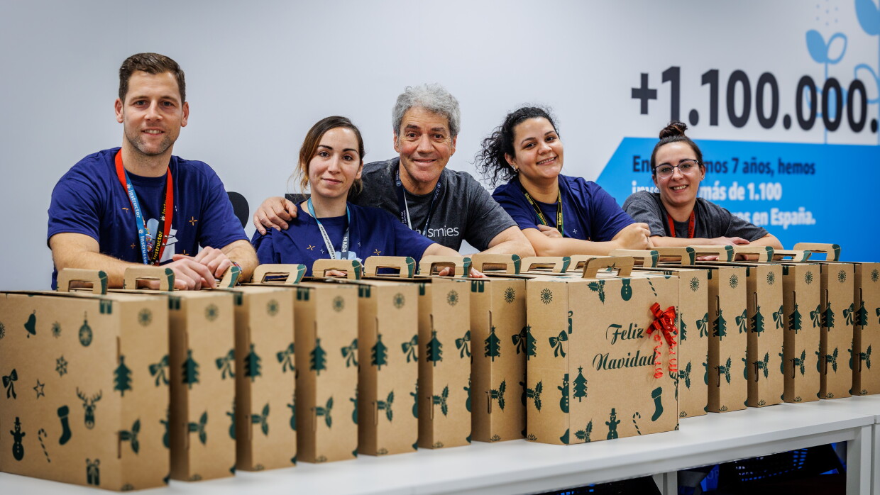 En una sala del centro logístico de MAD4 en San Fernando de Henares hay 5 voluntarios detrás de las cestas de Navidad. 