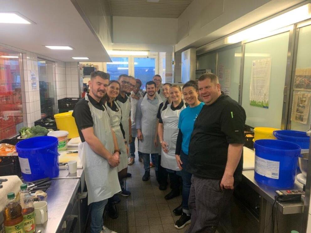 Mitarbeiter:innen halfen in einer Suppenküche dabei Mahlzeiten zuzubereiten.