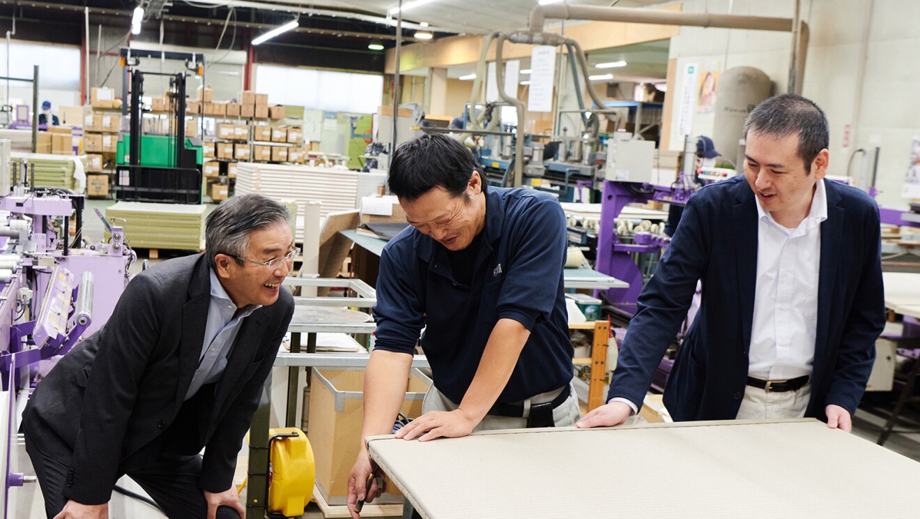 職人たちと笑顔で会話する男性