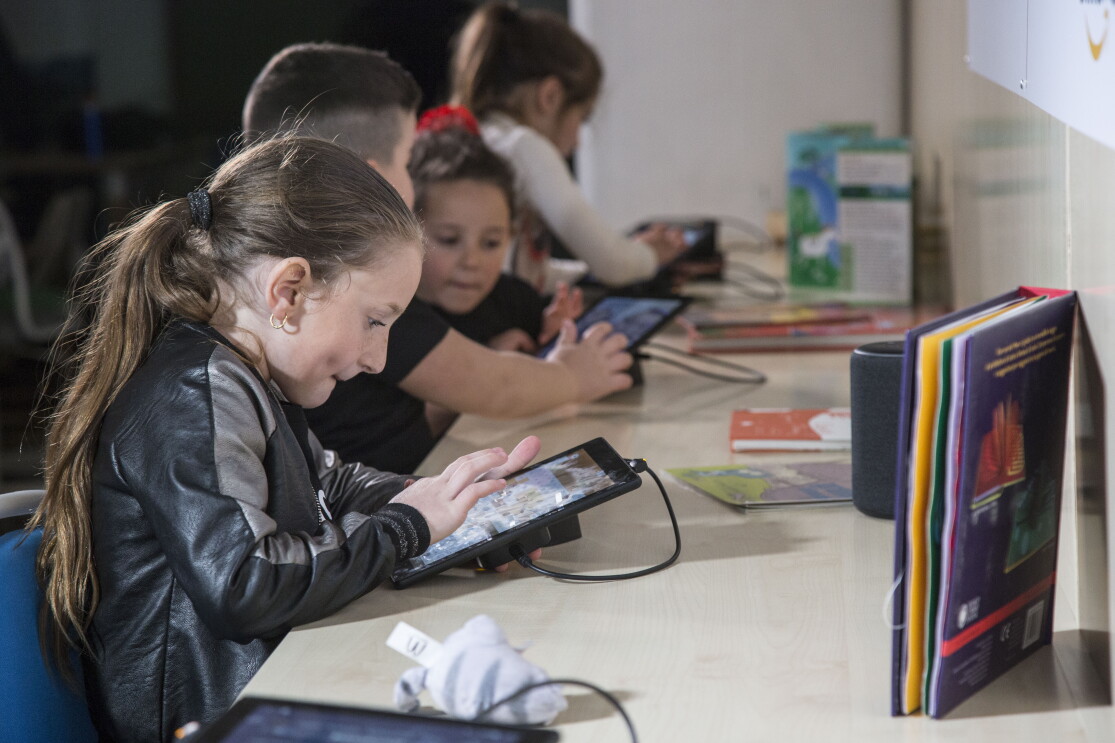 Bambini giocano con i tablet Fire messi a disposizione da Amazon per la sala multimediale della Biblioteca di Scampia