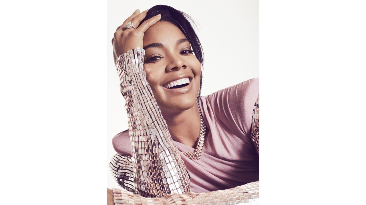 Gabrielle Union smiles wearing a silver bejeweled shirt.