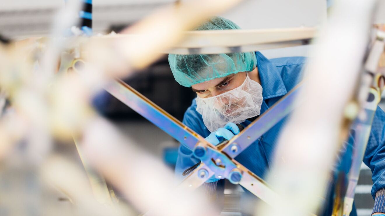 An employee with hairnet and mask working in a Kuiper facility
