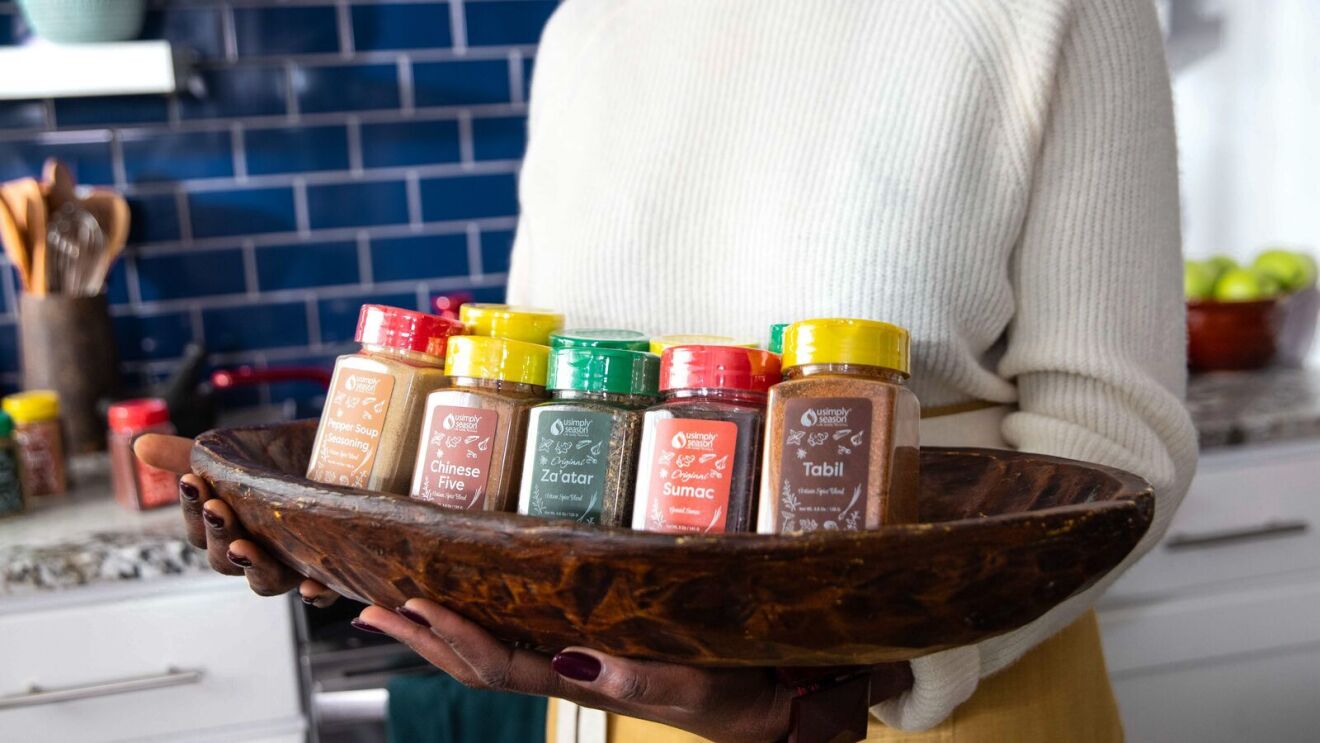 closeup of sylvia kapsandoy holding a long platter filled with spices, including chinese five space, za'atar, sumac, and tabil