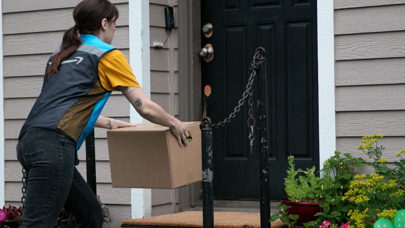 Amazon delivery person placing package at front door