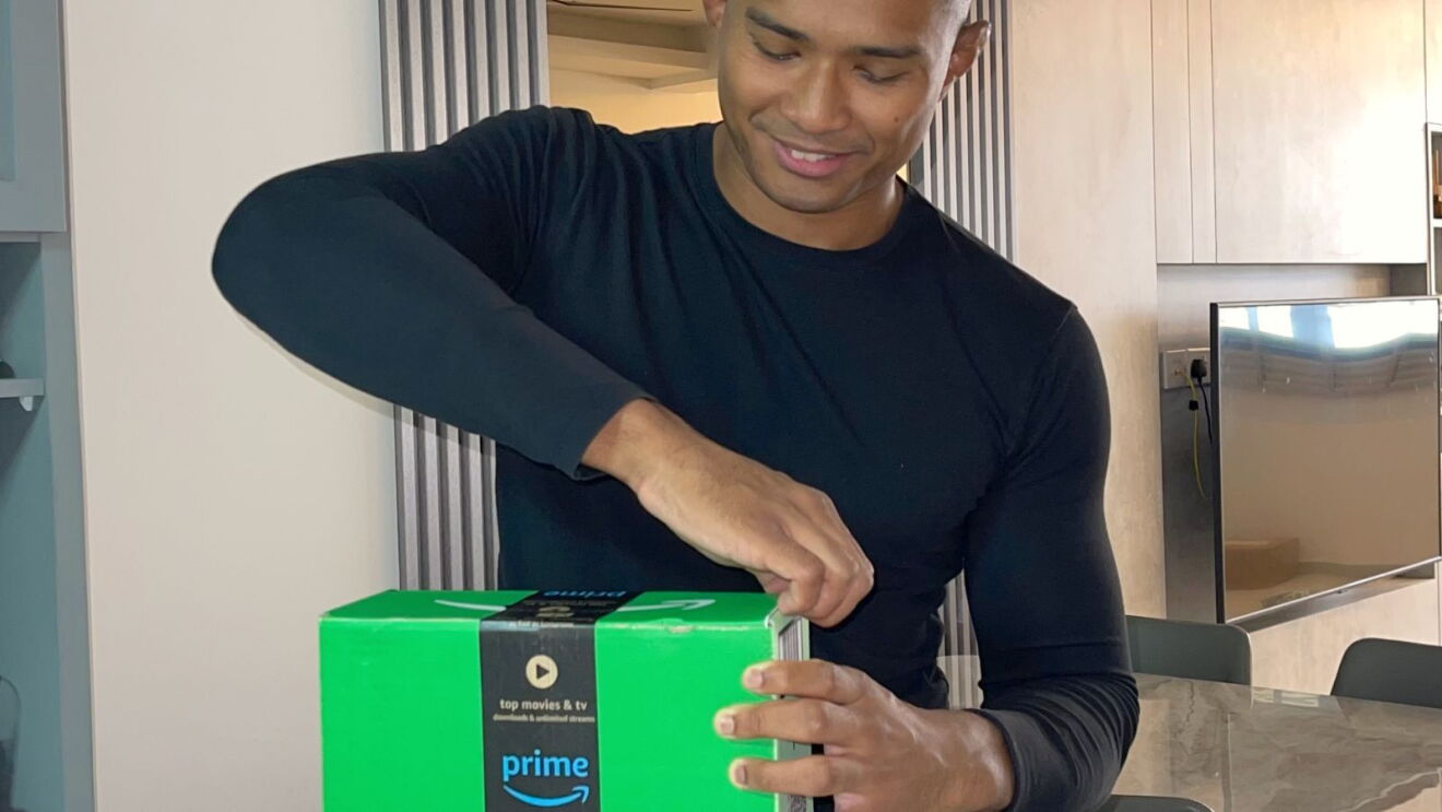 MMA fighter Amir Khan opening an Amazon package.