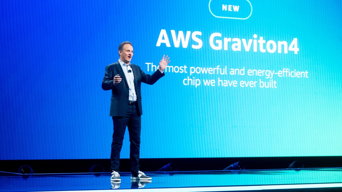 A photo of Adam Selipsky, AWS CEO, standing on stage and presenting about the AWS Graviton4 chip at AWS re:Invent.