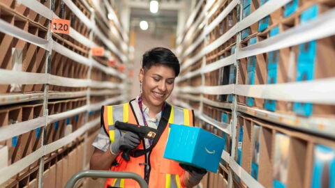 Trabajdora de un centro logístico de Amazon escaneando un producto. 