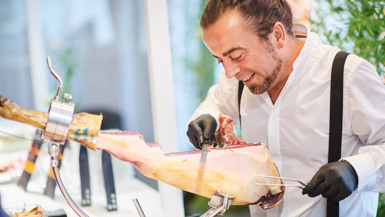 Redondo Iglesias specialized in traditional Spanish Ibérico and Serrano ham at Amazon Academy open marketplace exhibition, slicing ham for the visitors.