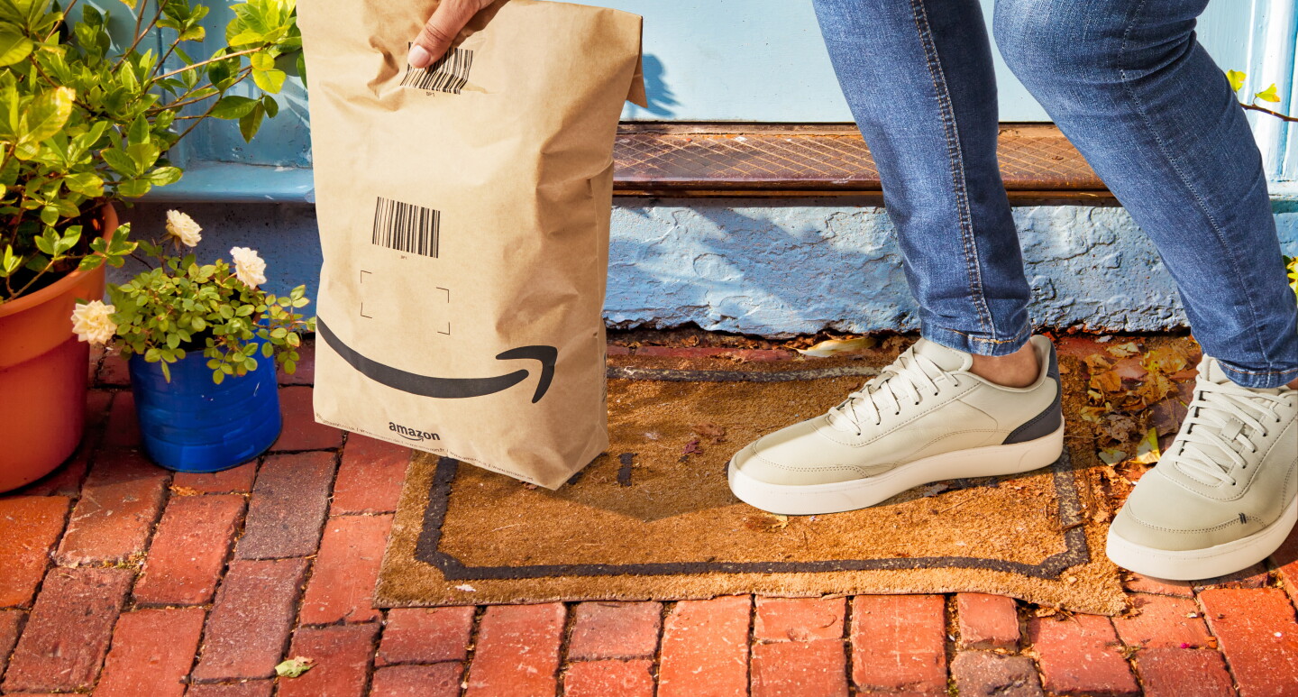 A customer picking up an Amazon delivery in a paper bag with less packaging