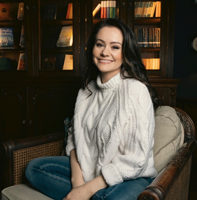 An author sitting down smiling