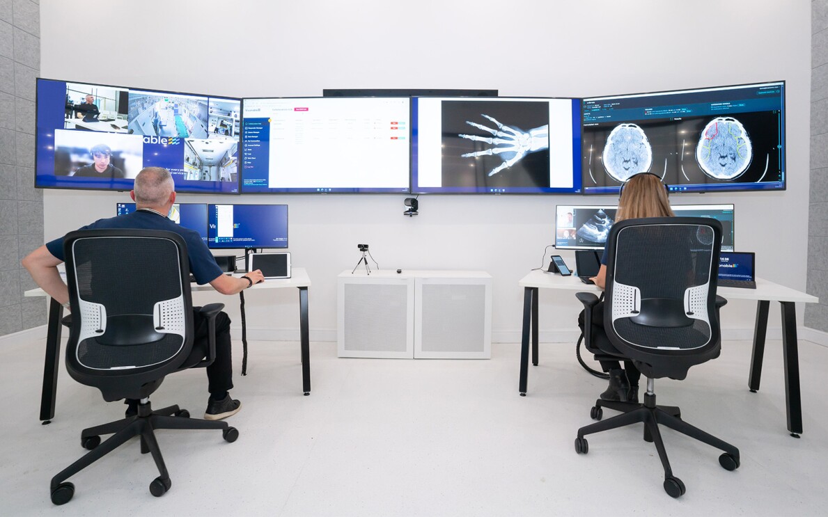 A photo of two staff members working on desktop devices, reviewing x-ray images.