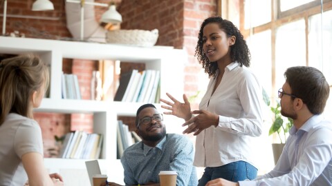 Ambitious african black female employee speaking at diverse meeting